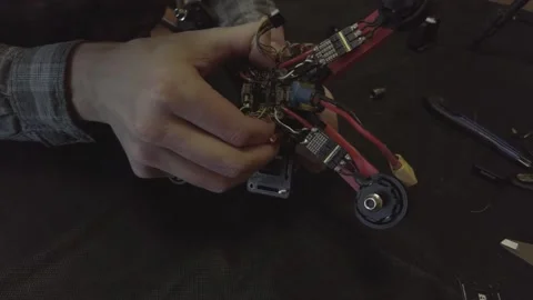 Disassembled FPV quadrocopter, do-it-yourself drone repair on a black table Stock Footage 168280264