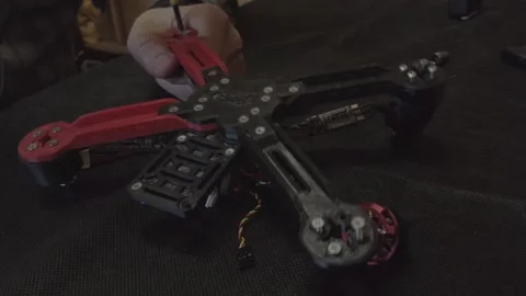 Disassembled FPV quadrocopter, do-it-yourself drone repair on a black table Stock Footage 168280396