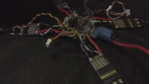Disassembled FPV quadrocopter, do-it-yourself drone repair on a black table Stock Footage 168280512