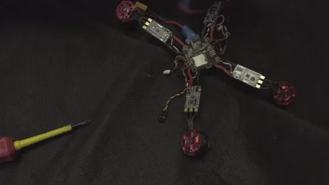 Disassembled FPV quadrocopter, do-it-yourself drone repair on a black table Stock Footage 168280516