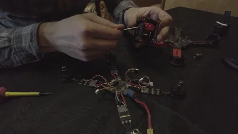 Disassembled FPV quadrocopter, do-it-yourself drone repair on a black table Stock Footage 168280631