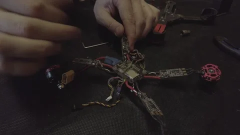 Disassembled FPV quadrocopter, do-it-yourself drone repair on a black table Stock Footage 168280695