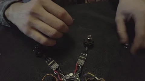 Disassembled FPV quadrocopter, do-it-yourself drone repair on a black table Stock Footage 168280718