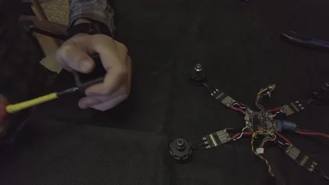 Disassembled FPV quadrocopter, do-it-yourself drone repair on a black table Stock Footage 168280720