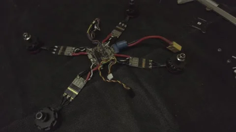 Disassembled FPV quadrocopter, do-it-yourself drone repair on a black table Stock Footage 168280845