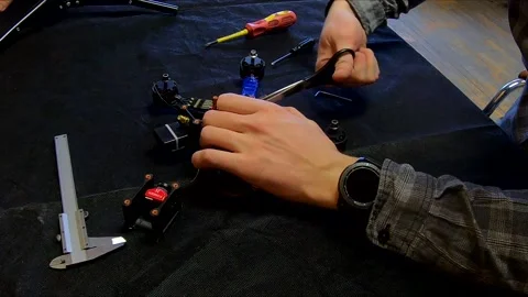 Disassembled FPV quadrocopter, do-it-yourself drone repair on a black table Stock Footage 168280977
