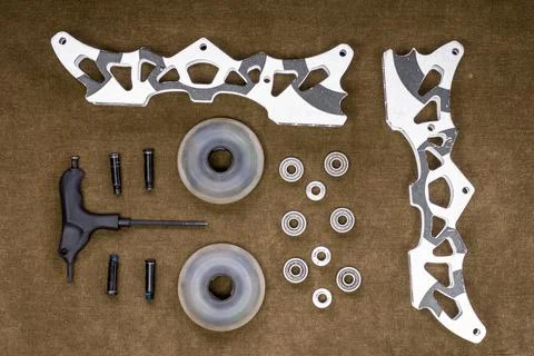Disassembled Inline Skates Frame Kit with Wheels Bearings and Tool Flat Lay Stock Photos