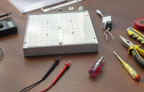 Disassembled led light fixture on table with tools Foto stock