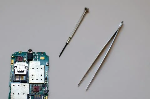 Disassembled mobile phone on the table of a mechanical engineer during repair Stock Photos