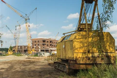 The disassembled old crawler crane on the background of a construction site Stock Photos