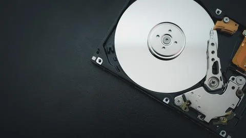 Disassembled open hard disk drive HDD of computer or laptop lies on dark ma.. Stock Photos