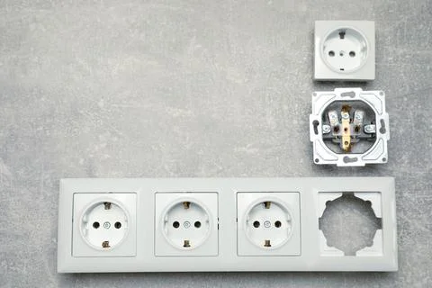 Disassembled power socket on grey table, flat lay. Space for text Stock Photos