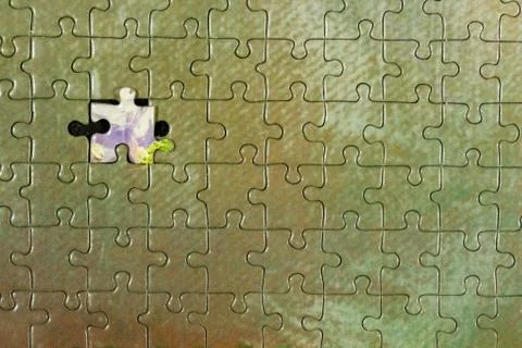 Disassembled puzzle with a last wrong piece impossible to fill Stock Photos