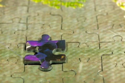 Disassembled puzzle with a last wrong piece impossible to fill Stock Photos