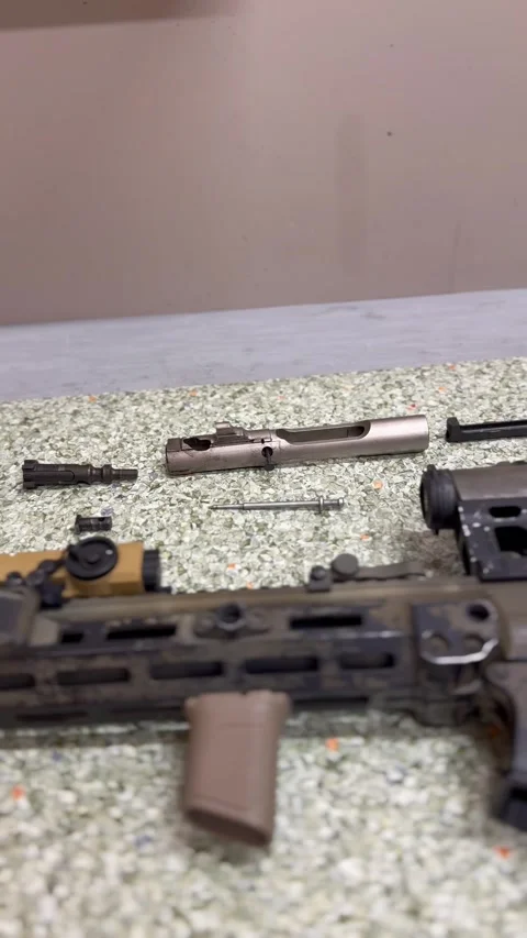 Disassembled rifle and weapon components on work surface Stock Footage 327072070