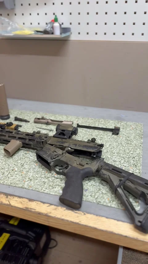 Disassembled rifle and weapon components on work surface Stock Footage 327072071