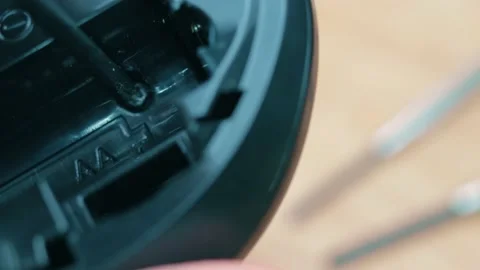 Disassembles wireless computer mouse, Hand unscrews the cover, close up view Stock Footage 158924763
