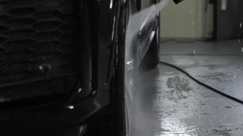 The disc of a black car is washed with a high-pressure washer at a car wash. Video stock 247086635
