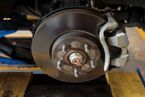 Disc brake of a car to be fixed at garage, shallow depth of field Stock Photos
