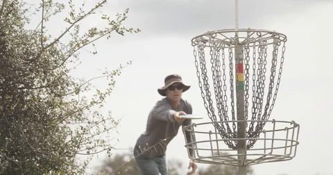 Disc golf putting into basket Stock Footage 104460537