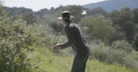 Disc golfer throwing disc off teepad Stock Footage 104460321
