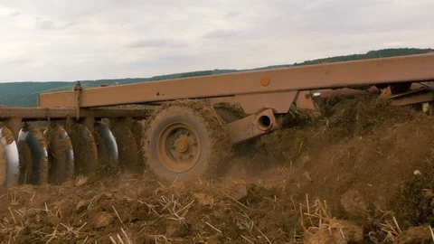 Disc harrow farming implement harrowing dry soil in slow motion Stock-Footage 95392538