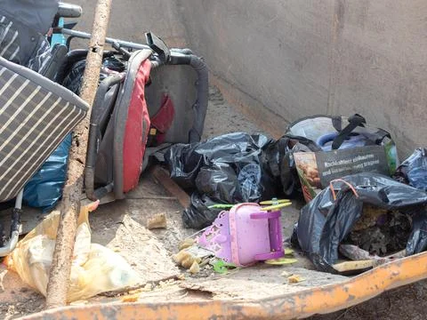 Discarded Baby Strollers Thrown Away in a Large Metal Dumpster Stock Photos