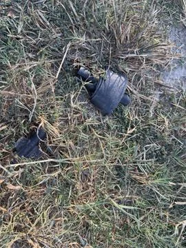 Discarded Black Plastic Pieces in Grass Stock Photos