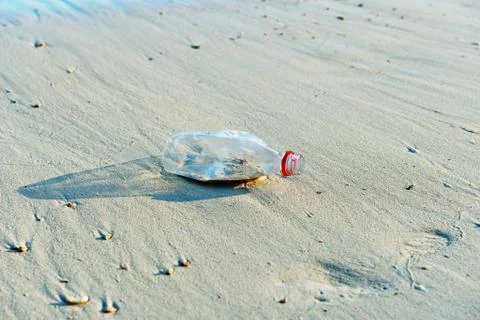 Discarded bottle washed up on beach Stock Photos