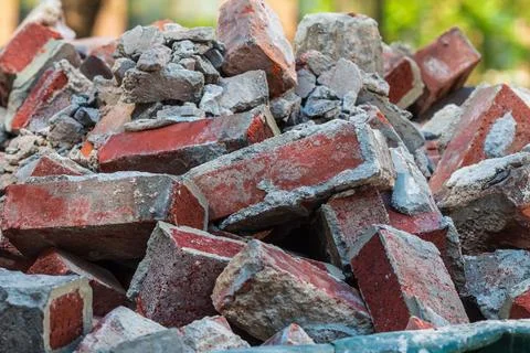 Discarded bricks are piled high in construction dumpster Stock Photos