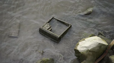 Discarded computer case in the side of a river Stock Footage 64658675