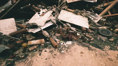 Discarded debris and scrap materials litter an industrial site during daylight Stock Footage 304513066