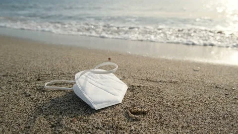 Discarded disposable face mask floating on dirty sea shore,covid19 pollution Stock Footage 152798789