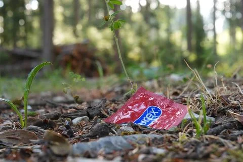 Discarded Durex Condom Wrapper on Forest Floor Stock Photos