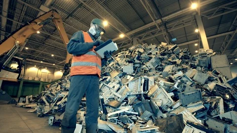 Discarded electronics and a landfill worker inspecting it Stock Footage 127416350