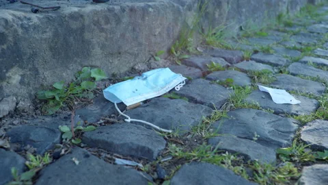Discarded face mask on the ground during corona 4k 50p Stock Footage 130785964