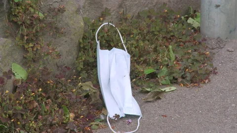 Discarded face mask on the ground during corona 4k 50p Stock Footage 135452910