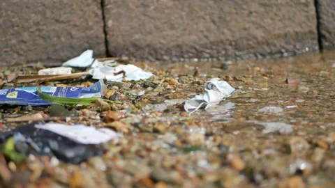Discarded facemask gets washed up ashore with other COVID-19 disposable masks. Stock-Footage 152956980