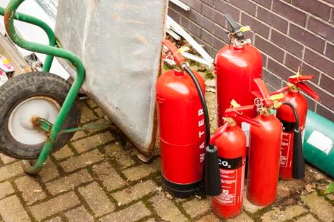 Discarded fire extinguishers in a builders yard Stock Photos