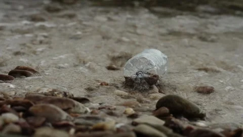 Discarded plastic bottle lying on sandy beach, environmental pollution Stock Footage 317883045