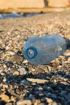 Discarded single -use face mask. Medical face mask on a beach. Stock Photos
