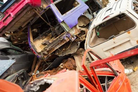 Discarded vehicles rust on scrapyard Stock Photos