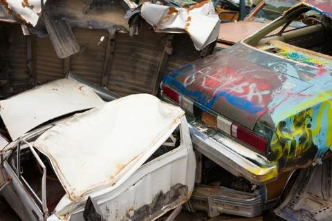 Discarded vehicles rust on scrapyard Stock Photos