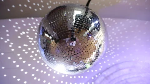 Disco ball with bright rays under the ceiling, night party. Stockbeeldmateriaal 177504504