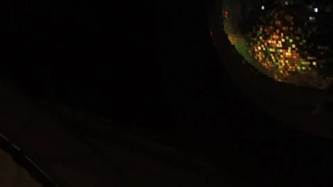 A disco ball with a corner of the frame is periodically illuminated by a Stock Footage 155211355