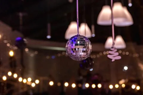 Disco ball is hanging from the ceiling in a dimly lit room Stock Photos