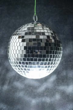 Disco ball hanging is comprised of small mirrors and has a light reflecting.. Stock Photos