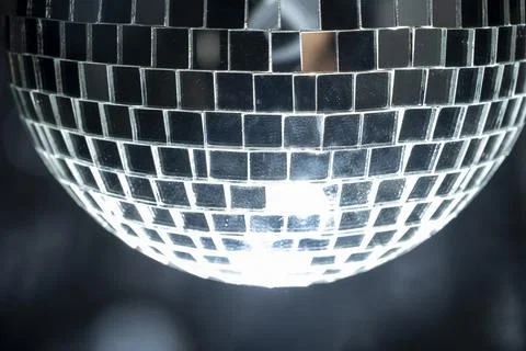 Disco ball hanging is comprised of small mirrors and has a light reflecting.. Stock Photos