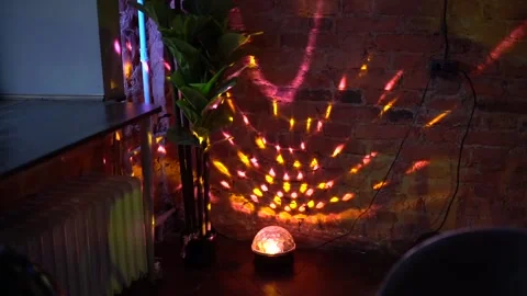 Disco Ball Light Projector Casting Colorful Patterns on Brick Wall Stock Footage 329752184