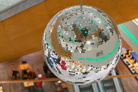Disco ball in a lively indoor setting, reflecting surrounding rows of tables  Stock Photos
